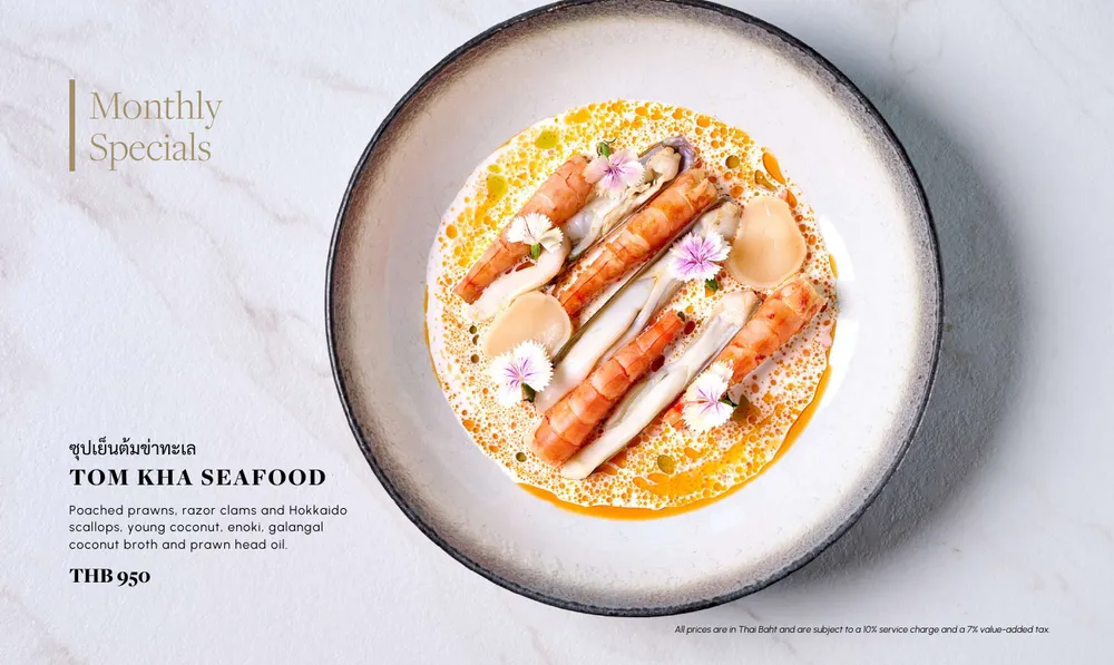 Restaurant menu page with a bowl of prawns in coconut broth, its price and a footnote on service charge and value-added tax.